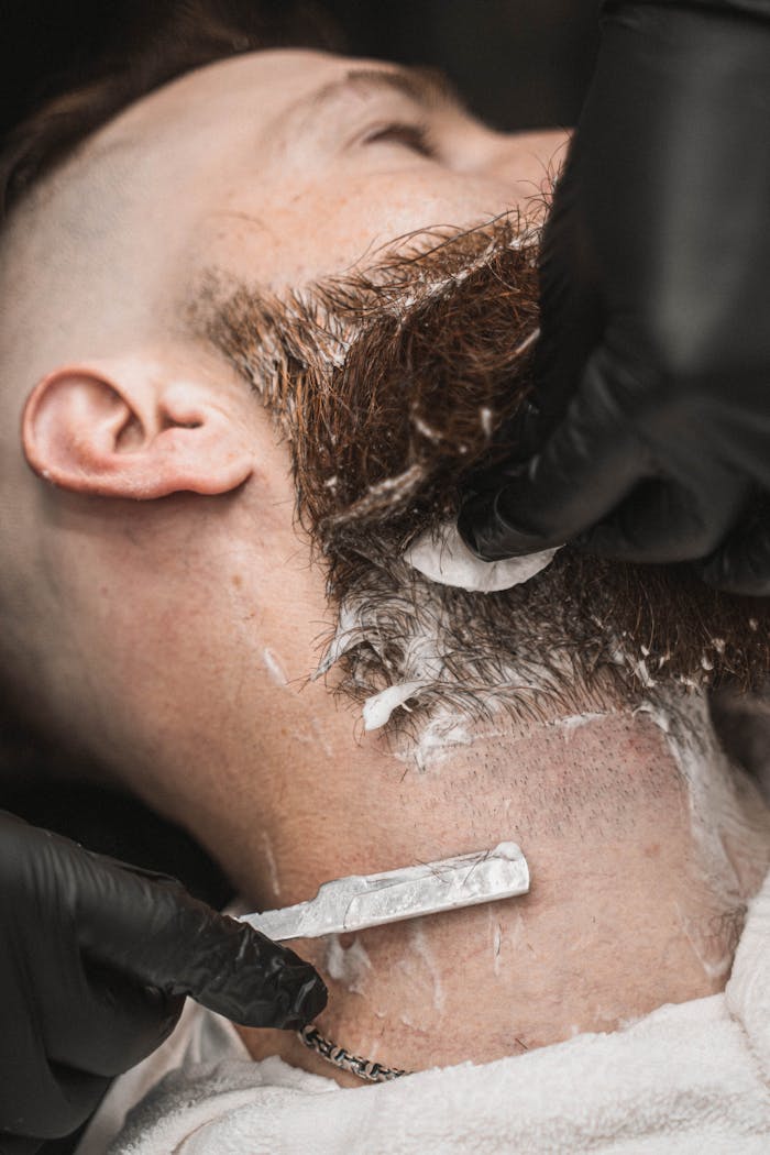 Barber expertly shaving a man