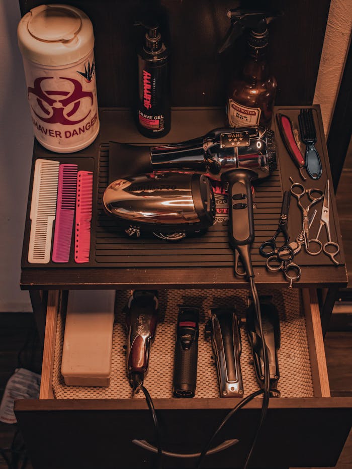 A comprehensive set of barber tools including clippers and scissors arranged neatly on a wooden stand.